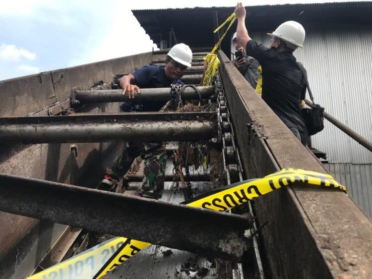 Petugas memasang police line di TKP kematian Operator Loading Ramp