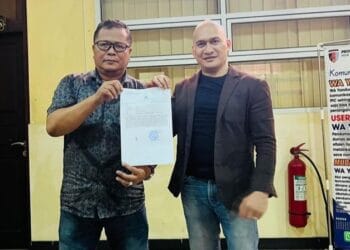 Kadis Pariwisata Kabupaten Solok, Armen bersama kuasa hukum pemkab Solok, Suharizal saat menunjukkan dokumen laporan polisi atas dugaan penyerobotan tanah Pemda oleh masyarakat di Nagari Alahan Panjang.(Ist)