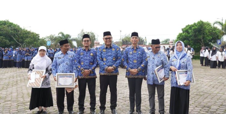 Bupati Solok, H. Epyardi Asda saat memberikan penghargaan kepada guru pada peringatan HUT Korpri dan PGRI tahun 2023 di Kabupaten Solok.(Ist)