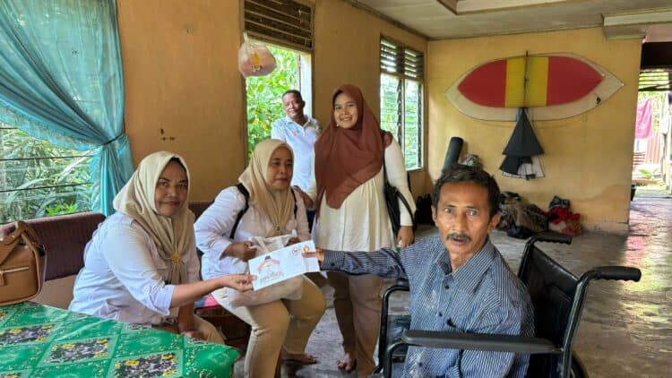 Andre Rosiade Bantu Penderita Diabetes yang Duduk di Kursi Roda di Seberang Padang