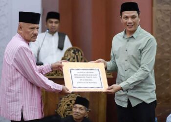 Wakili Wawako Solok, Komisioner KPU Kota Solok, Yance Gafar menyerahkan bantuan ramadhan untuk Masjid Nurul Hidayah Tanah Garam.(Ist)