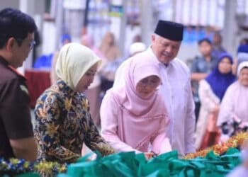 Ketua TP PKK Kota Solok, Ny. Zulmiyetti Zul Elfian menggunting pita tanda dimulainya bazar murah Ramadhan Kejari dan IAD Solok.(Ist)