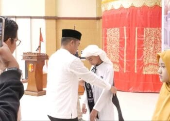 Wakil Wali Kota Solok, Dr. Ramadhani Kirana Putra memasangkan selempang tanda wisuda tahfiz kepada salah seorang peserta.(Prokomp)