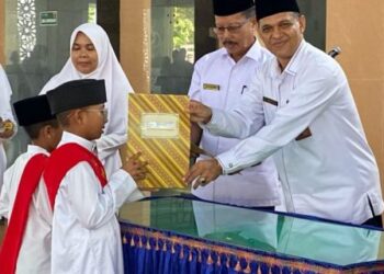 Kakan Kemenag Kota Solok bersama Asisten I menyerahkan sertifikat kepada pelajar yang mengikuti wisuda tahfiz.(Ist)