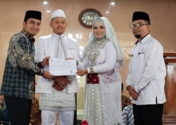 Wakil Wali Kota Solok, Ramadhani Kirana Putra menyerahkan dokumen kependudukan hasil inovasi one for eleven kepada salah satu pasangan yang menikah di Masjid Agung Al-Muhsinin.(Ist)