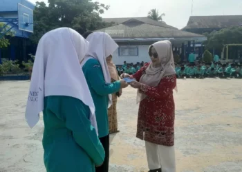 Kepala Disdukcapil Kota Solok, Ratnawati menyerahkan KTP el kepada pelajar SMA N 1 Kota Solok.(Ist)