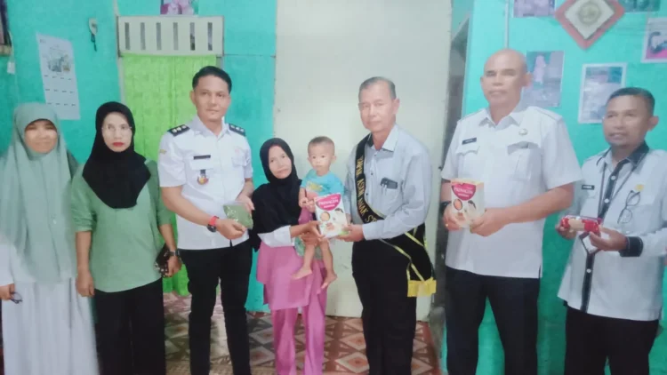 Ketua Baznas, Zaini bersama jajaran DPPKB Kota Solok menyalurkan bantuan bagi anak penderita stunting.(Ist)