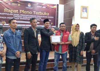 Ketua KPU, Hasbullah Alqomar menyerahkan berita acara penetapan hasil Pilkada Solok 2024 kepada Ketua Bawaslu, Titony Tanjung.(Ist)