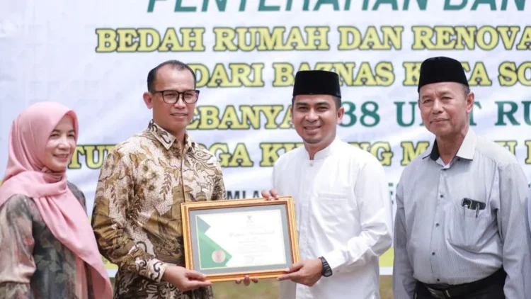 Wakil Wali Kota Solok, Dr. Ramadhani Kirana Putra menyerahkan penghargaan kepada donatur tetap Baznas Kota Solok, dr. Helwi yang mendukung program bedah rumah.(Ist)