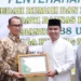 Wakil Wali Kota Solok, Dr. Ramadhani Kirana Putra menyerahkan penghargaan kepada donatur tetap Baznas Kota Solok, dr. Helwi yang mendukung program bedah rumah.(Ist)