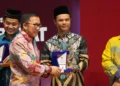 Ketua KPU Kabupaten Solok, Hasbullah Alqomar menerima penghargaan dari plt. Sekda Sumbar.(Ist)