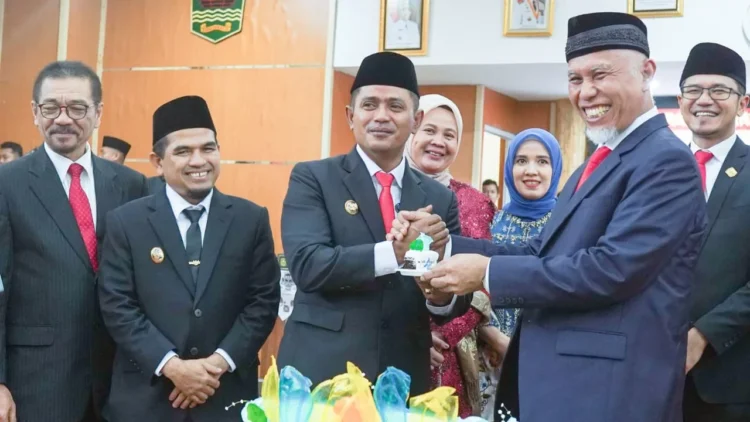 Bupati Solok, Jon Firman Pandu menyerahkan potongan kue kepada Gubernur Sumbar, Mahyeldi di sela peringatan HUT ke-12 Kabupaten Solok di Arosuka.(Ist)