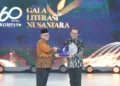Menteri Pendidikan Dasar dan Menengah RI, Abdul Mu'ti (kiri) ketika memberikan Apresiasi Literasi Nusantara 2025 kepada Direktur Utama PLN Darmawan Prasodjo yang diwakili oleh Sekretaris Perusahaan PLN Alois Wisnuhardana (kanan) pada agenda Hari Ulang Tahun (HUT) Ke-60 Harian Kompas di Jakarta pada Senin (30/6).