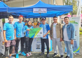 Kepala BPJS Ketenagakerjaan Solok, Arief Sabara menyerahkan secara simbolis kartu peserta kepada Panitia Semen Padang Fun Run Tahun 2025
