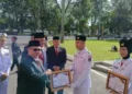 Ketua DPRD Sumbar, Muhidi saat menyerahkan plakat kepada Paskibraka usai upacara pancasila