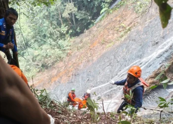 Tim saat mengevakuasi korban yang jatuh di Air Terjun Roboh Limapuluh Kota, Jumat (16/10/2026), jelang siang.